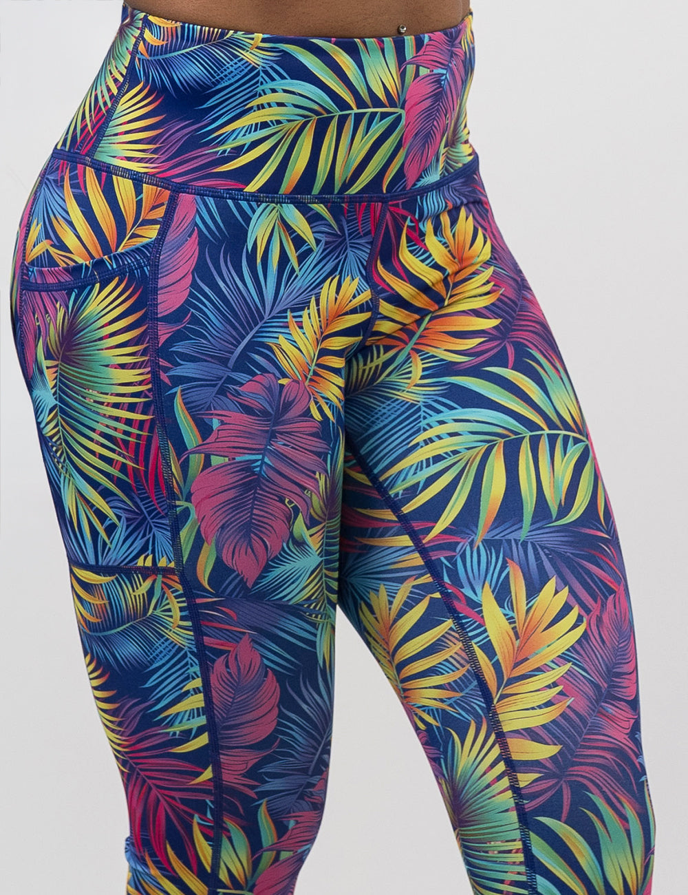 front of the vibrant rainforest leaves leggings against a white background