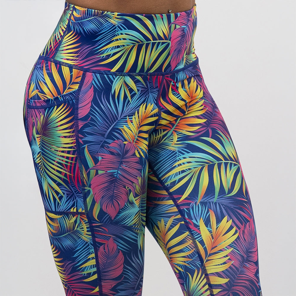front of the vibrant rainforest leaves leggings against a white background