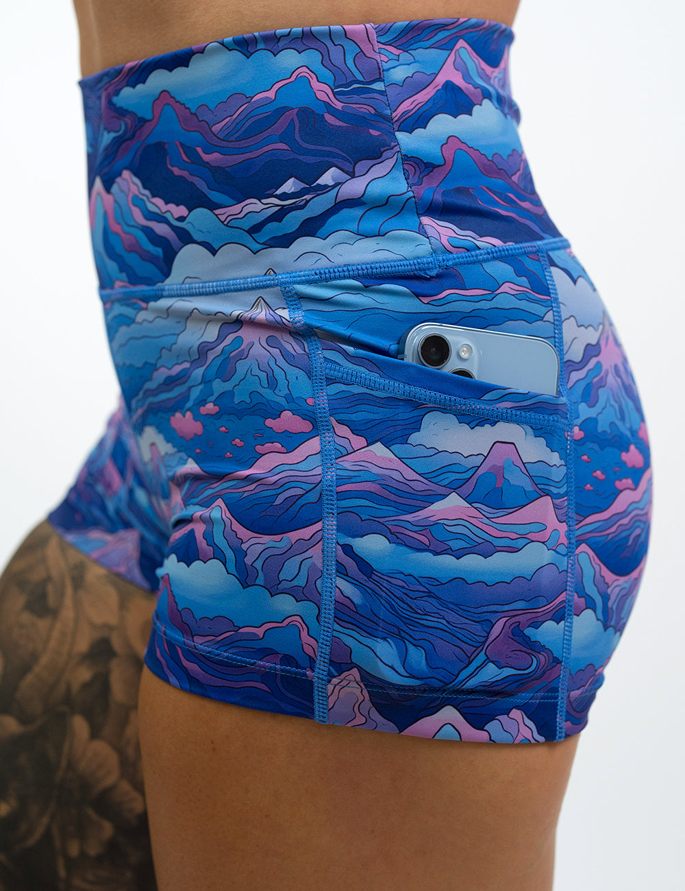 close up of the 2.5 inch blue and pink mountains shorts with a phone in the pocket