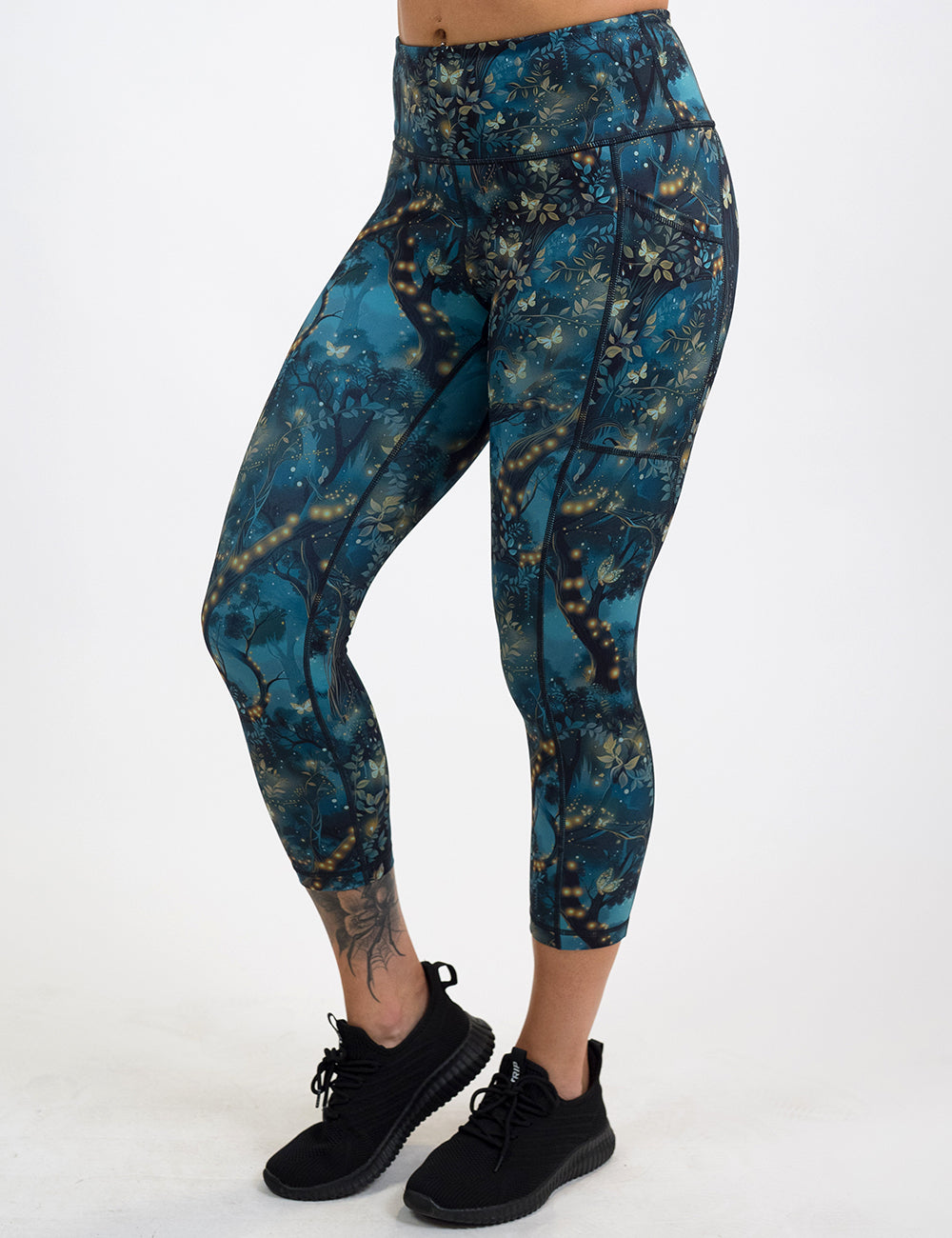 model wearing the capri forest filled with firefly's pattern leggings against a white background