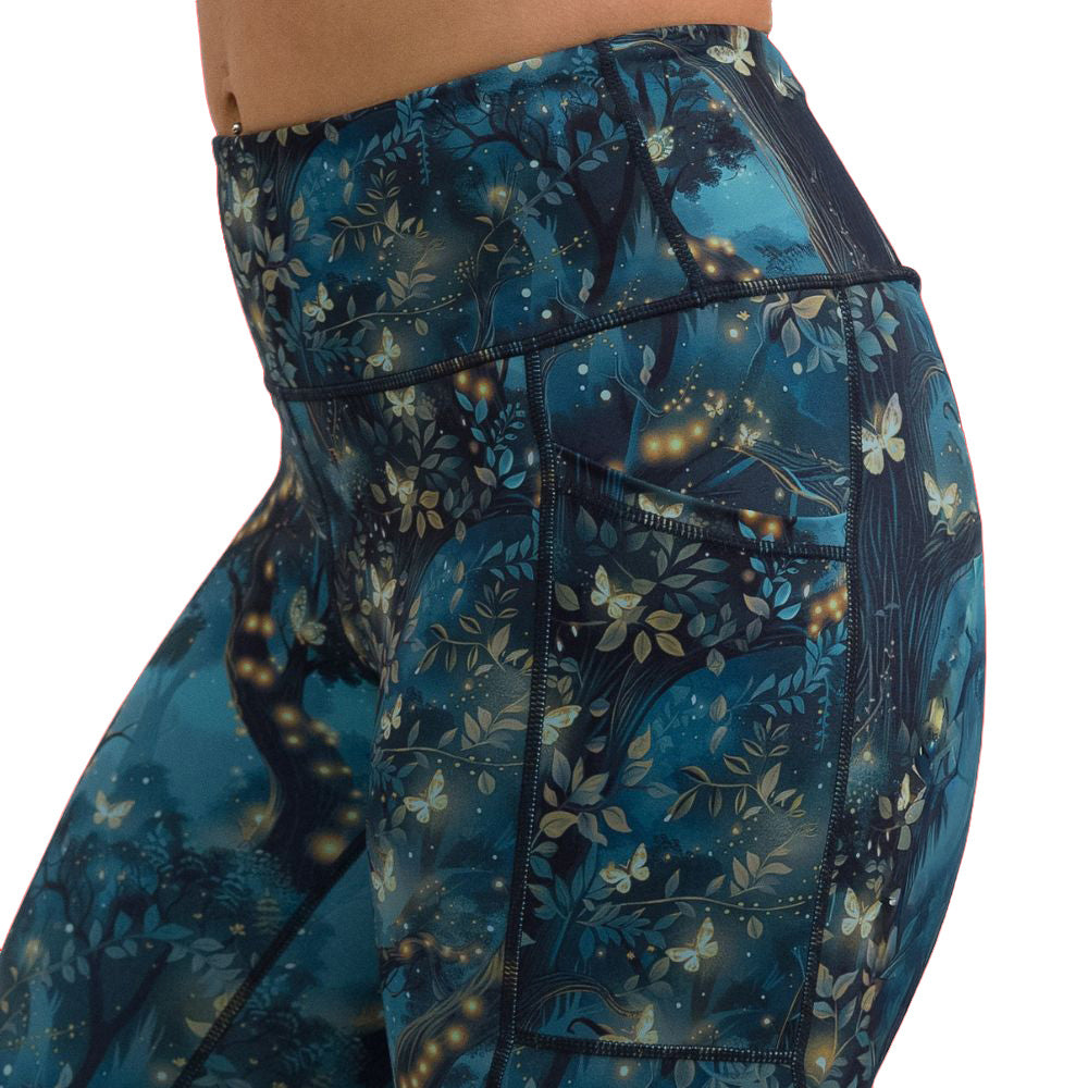close up of forest filled with firefly's pattern forest leggings against a white background