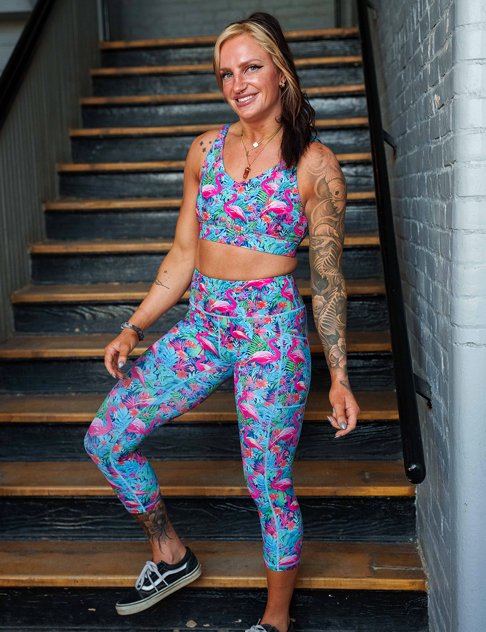 model wearing the capri colorful tropical flamingos leggings posing in a stairwell