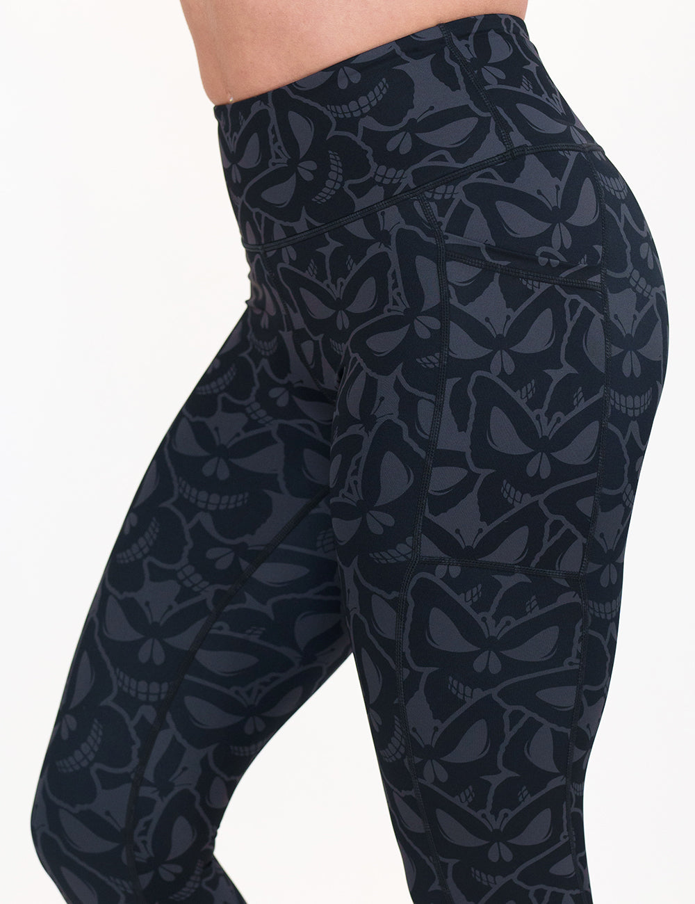 grey and black butterfly shaped skulls patterned leggings against a white background