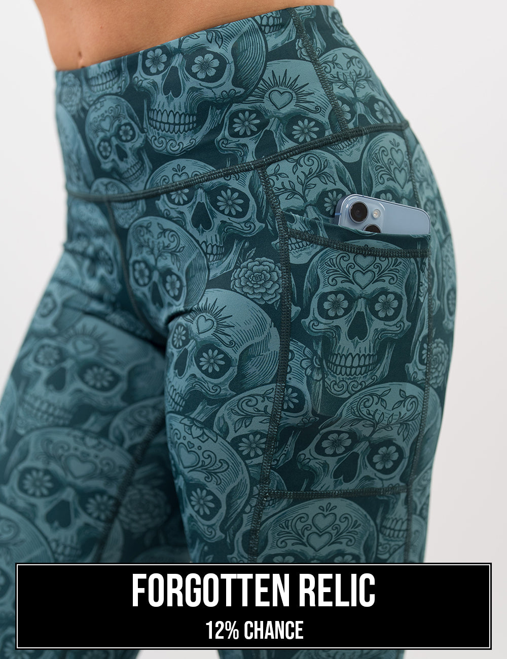 side view of the blue calavera skulls leggings with a phone in its pocket, the name of this print is forgotten relic and it has a 12% chance of being unboxed