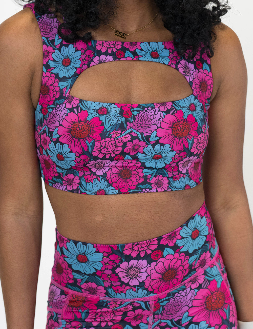 front of the pink and blue floral patterned sports bra against a white background