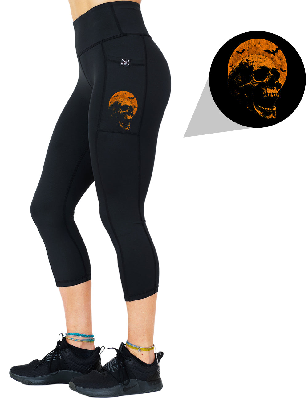 front of the orange skull in front of a orange moon graphic capri leggings