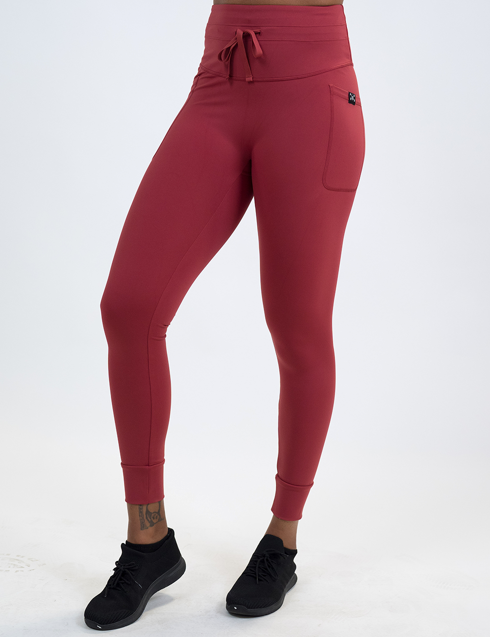 model wearing the full length red omni drawstring leggings facing the front against a white background