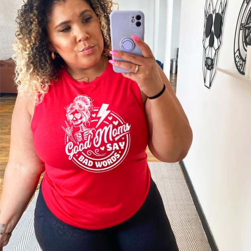 model wearing a red muscle tank with the saying "good moms say bad words" and a female skeleton rock symbol hand and lightning bolt