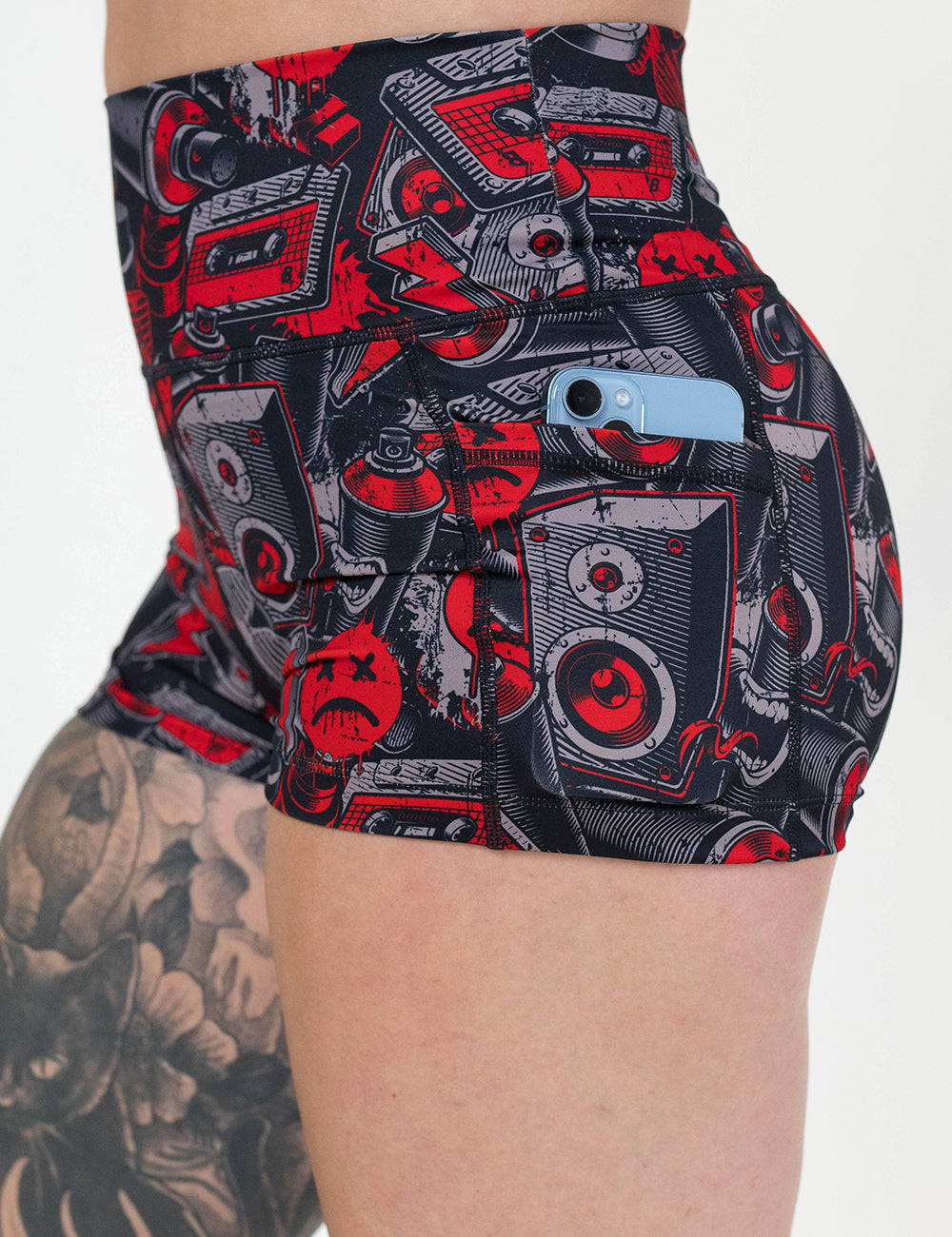 close up of the graffiti patterned 2.5 inch shorts with a phone in its pocket