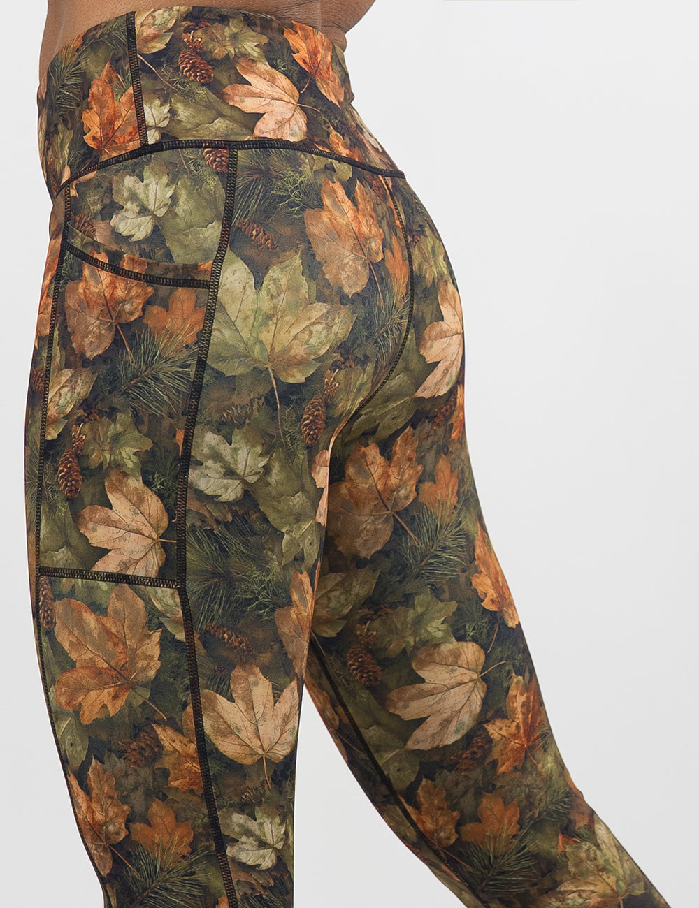 close up of the back of the forest floor covered in leaves leggings against a white background