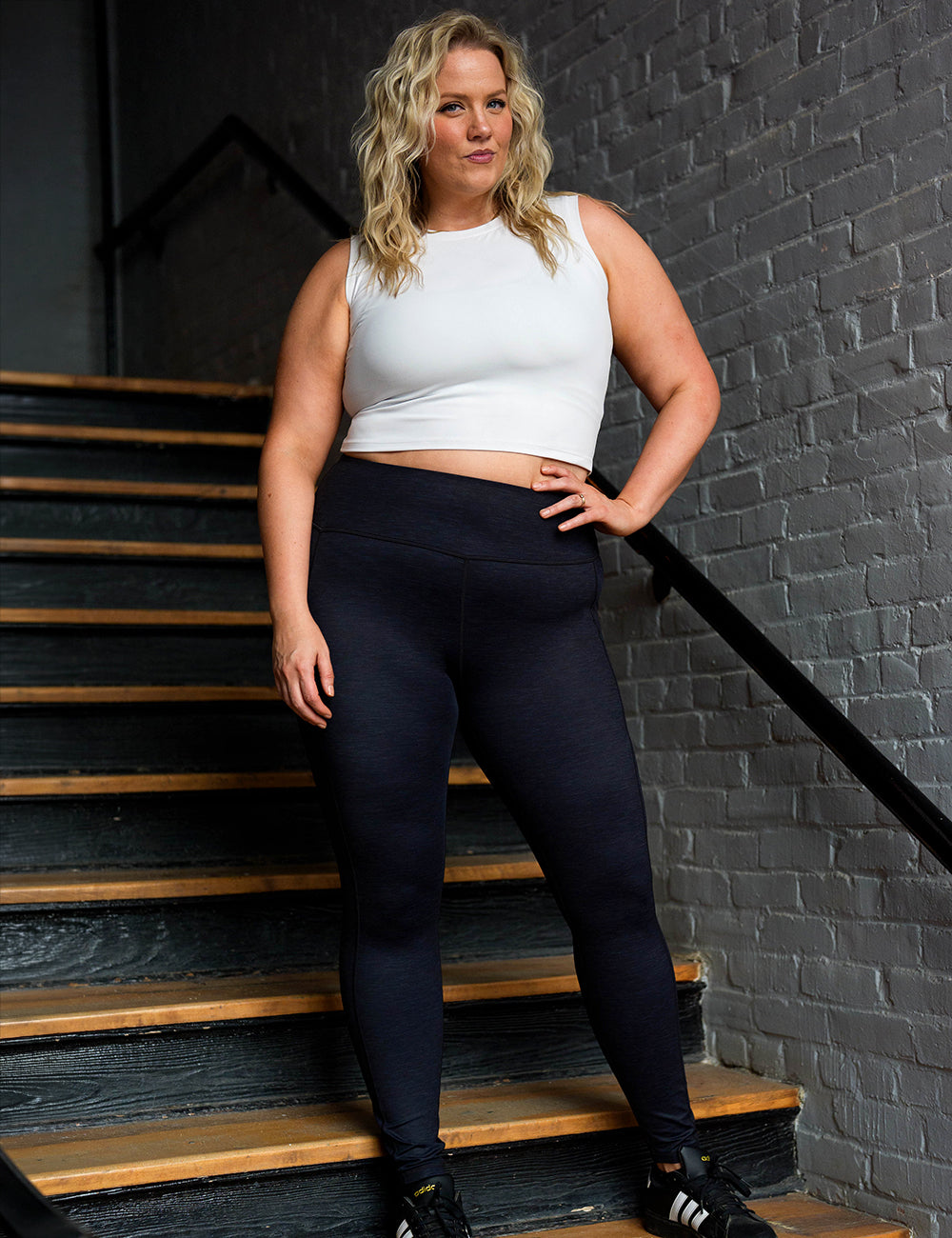 model wearing the full length black heather pattern leggings posing in a stairwell