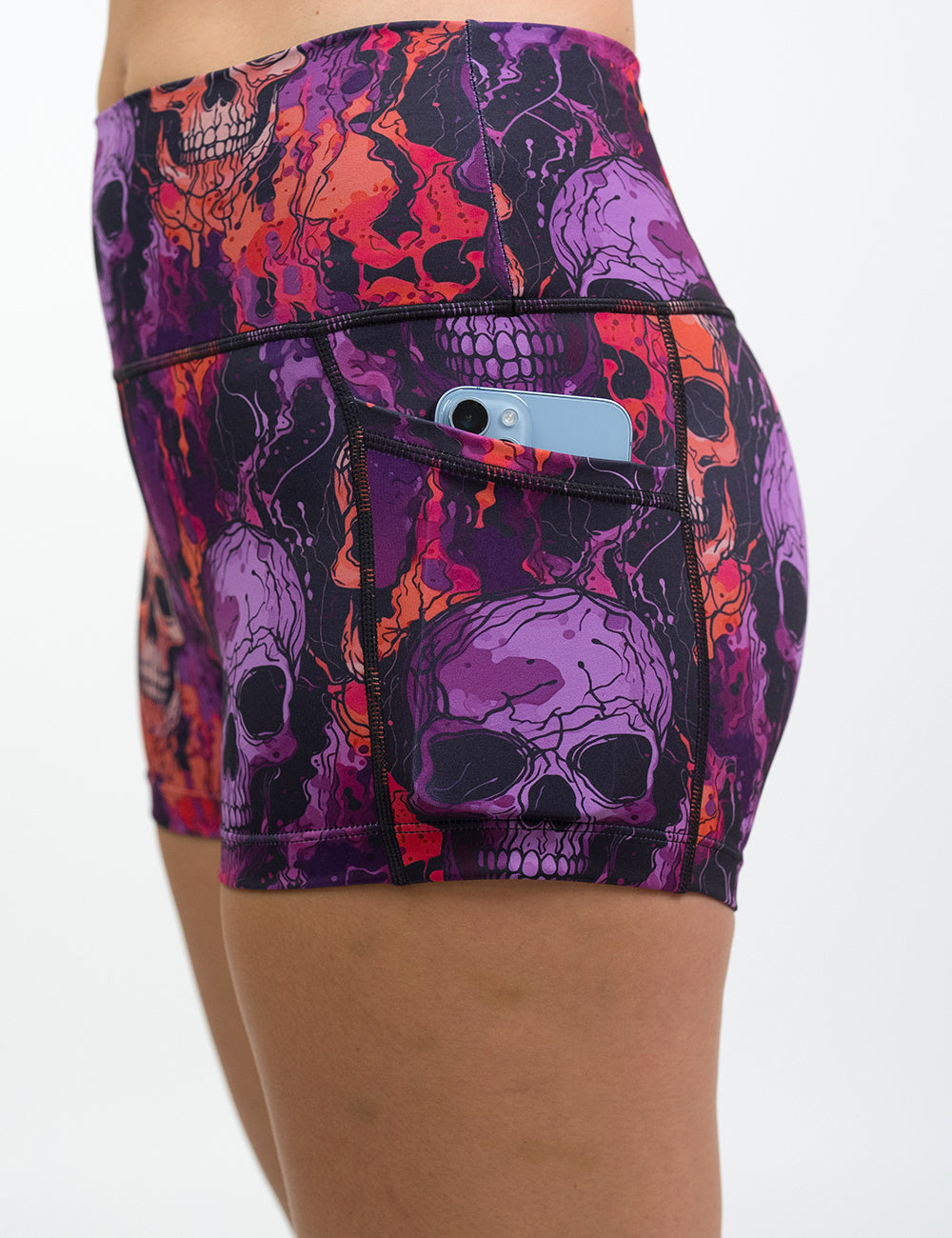 close up of the 2.5 inch purple and orange skull patterned shorts with a phone in its pocket