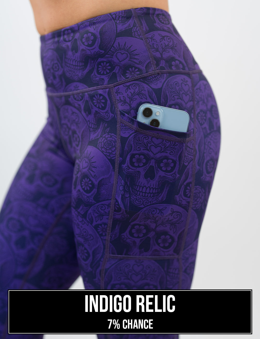 side view of the purple calavera skulls leggings with a phone in its pocket, the name of this print is indigo relic and it has a 7% chance of being unboxed