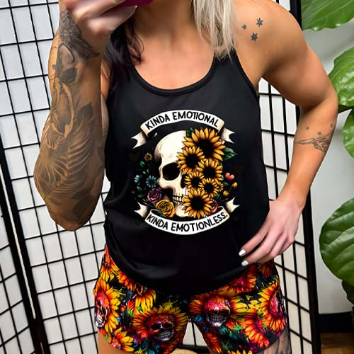model wearing a black racerback shirt that has a skull and flower graphic with the quote "Kinda Emotional Kinda Emotionless" on it
