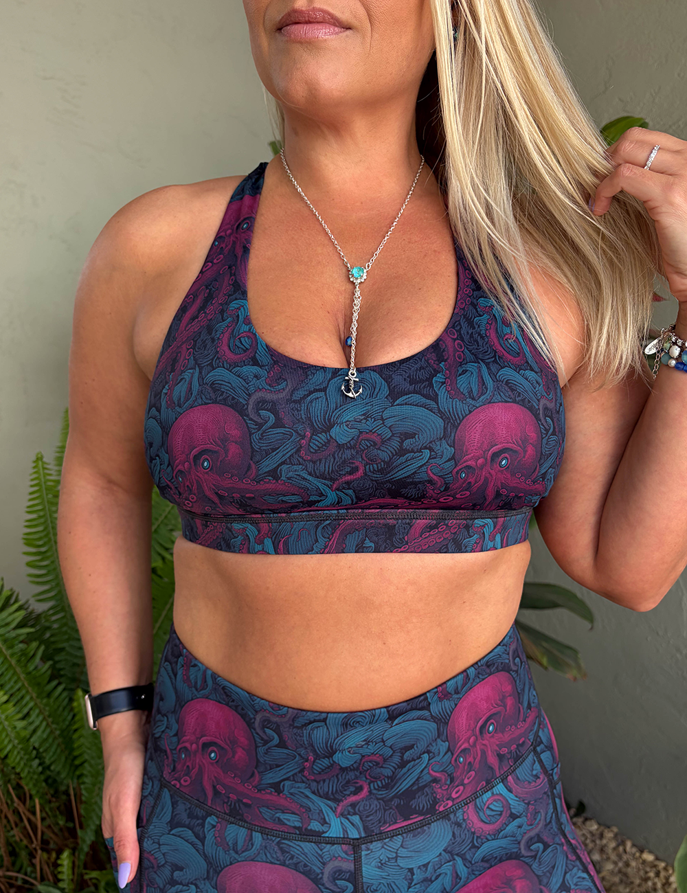 model wearing the butterfly back red octopus with blue eyes bra