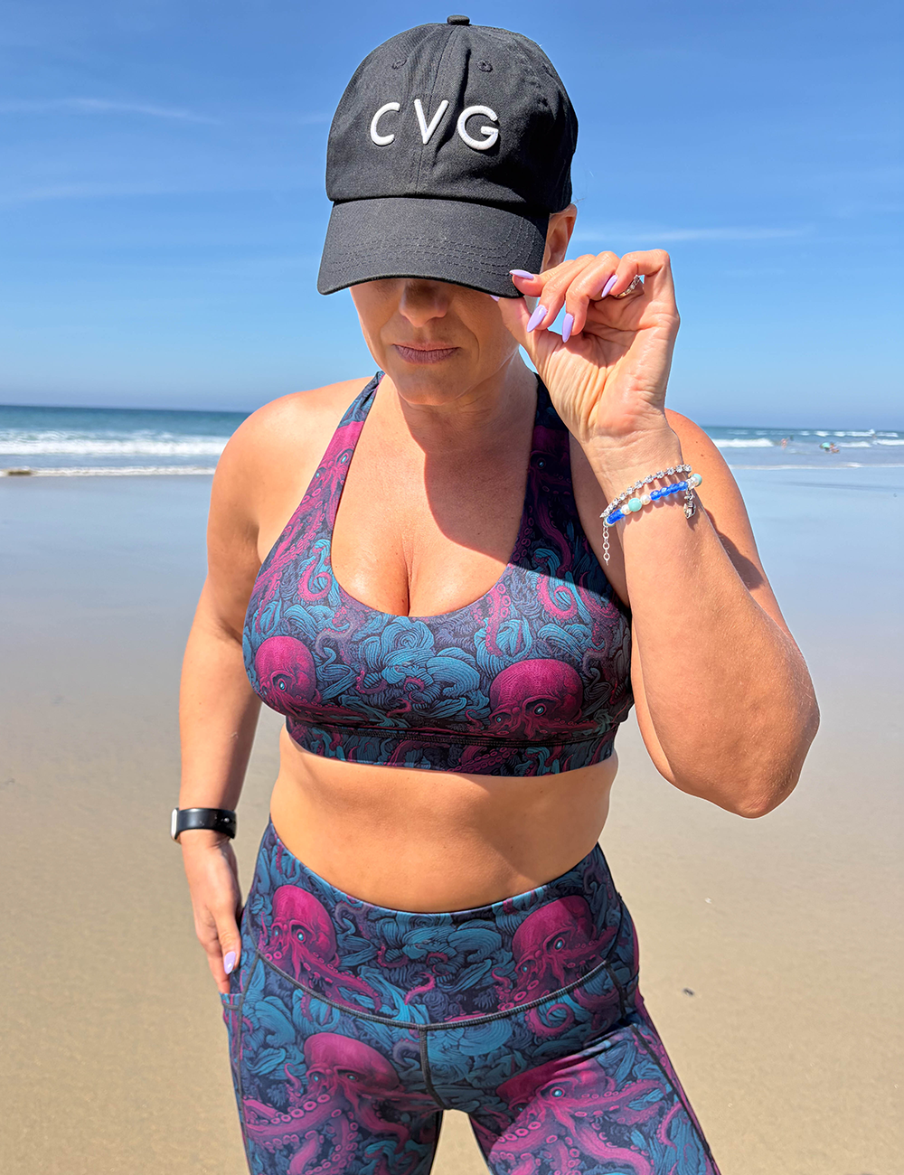 model wearing a CVG hat and the red octopus butterfly back bra and leggings at the beach