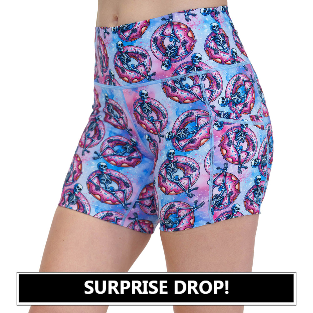 shorts with a skeleton on a donut pool floaty pattern on them