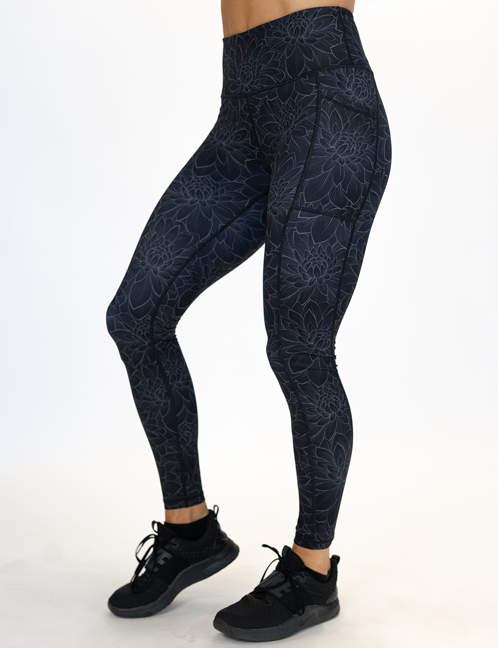 model wearing the full length black lotus flower leggings against a white background