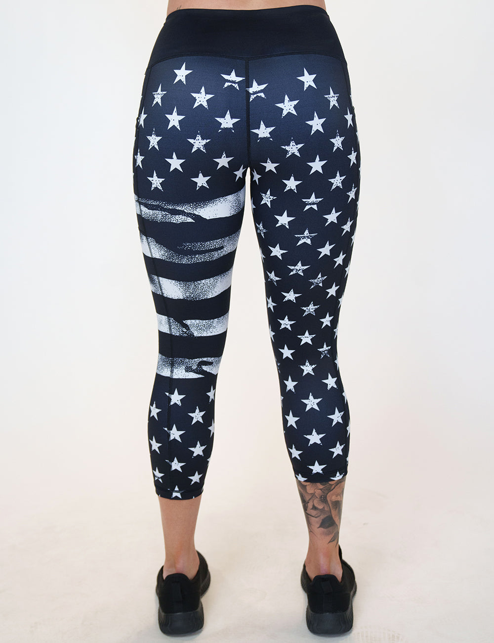 back of the capri black leggings with white American flag design on it against a white background
