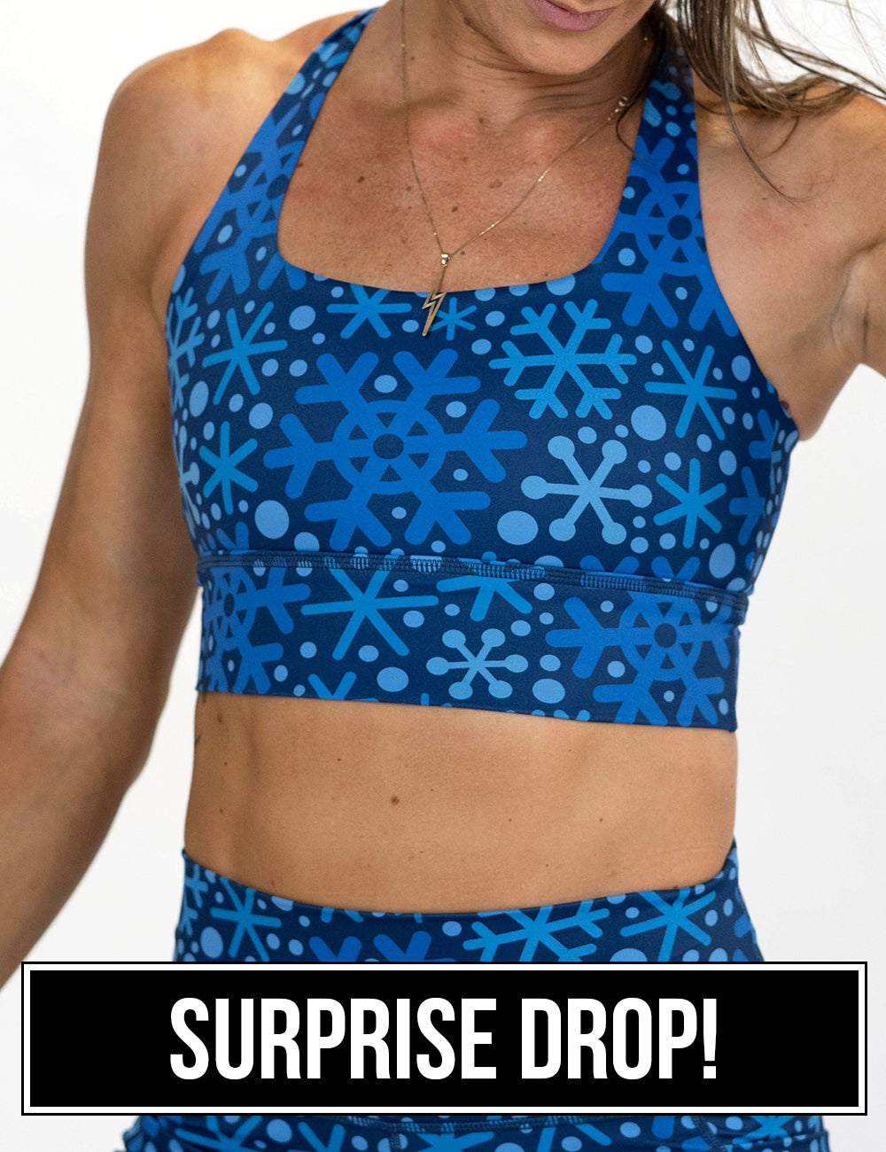 front of the blue snowflakes on a dark blue background sports bra, surprise drop