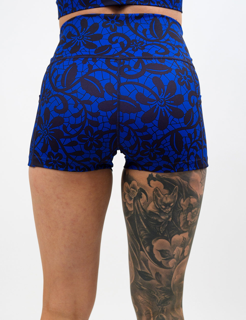back of the 2.5 inch black floral against a dark blue background shorts against a white background