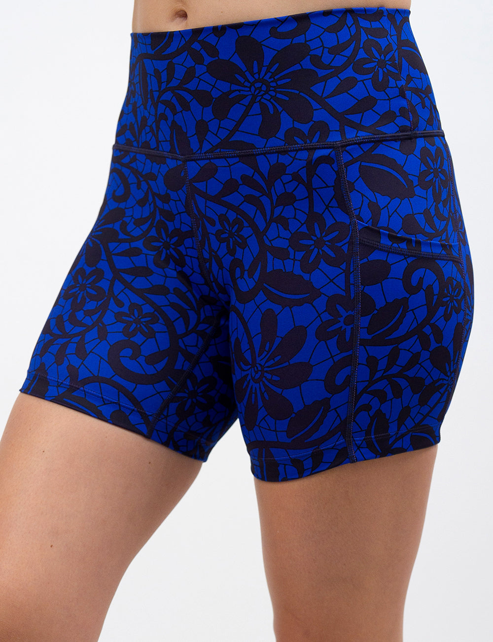 front of the 5 inch black floral against a dark blue background shorts against a white background