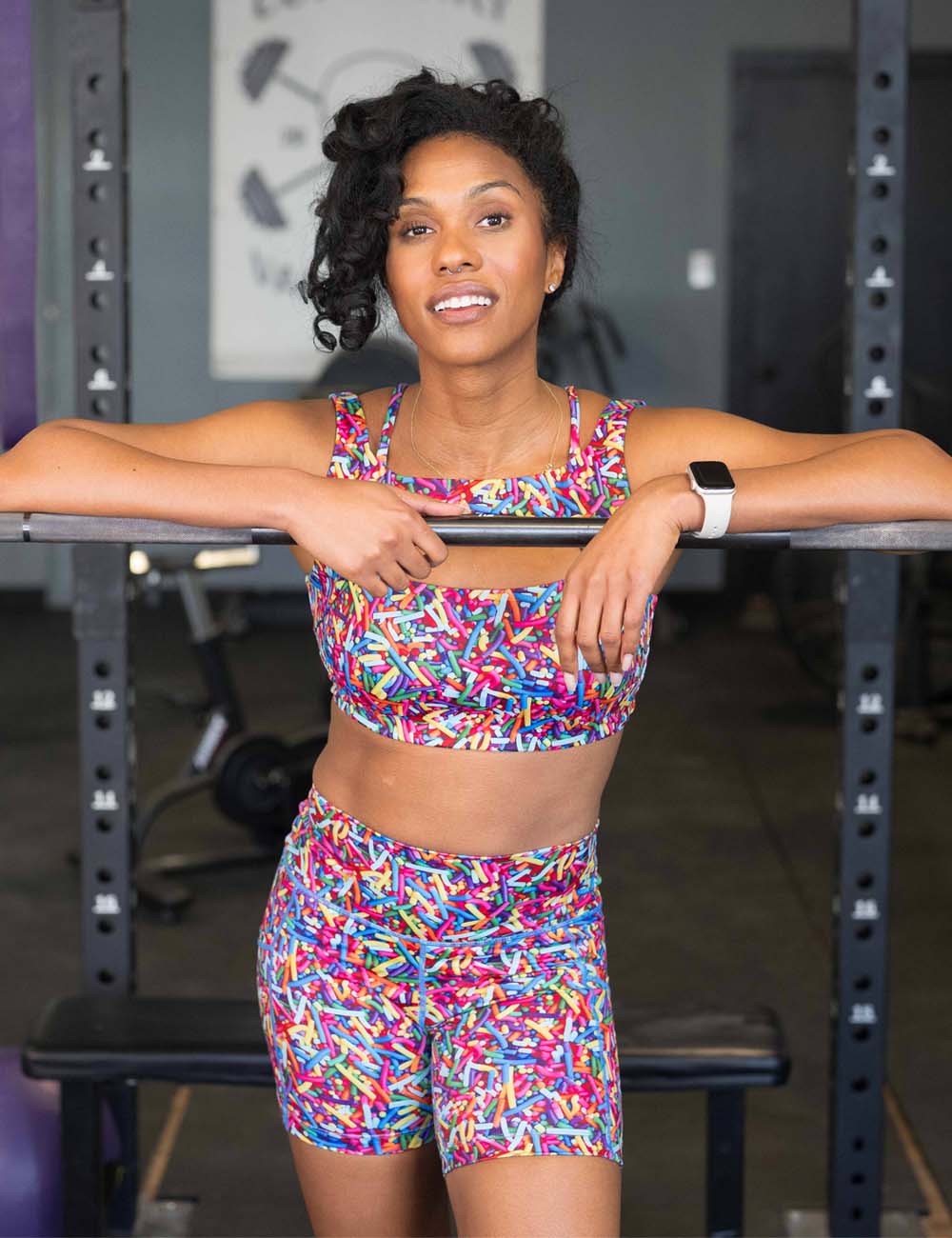 Woman in sprinkle shorts and bras posing in a gym setting