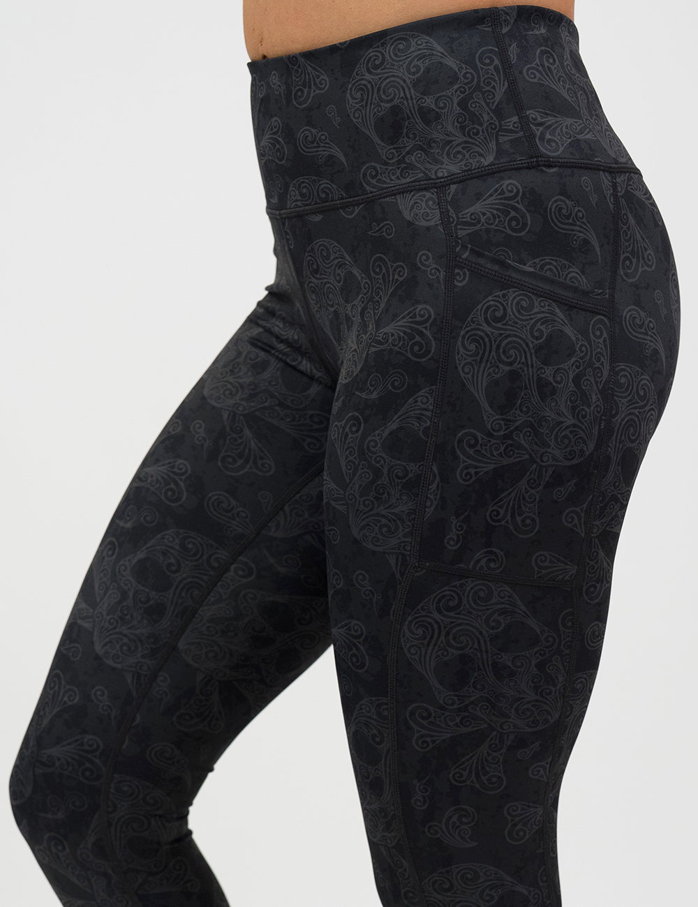 close up of dark pirate themed skull and cross bones leggings against a white background