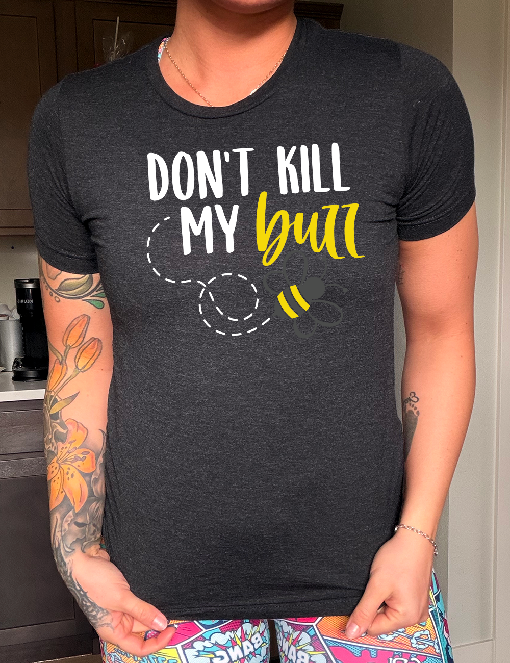 black unisex tee with the words "don't kill my buzz" on it, with a dashed trail leading to a bee graphic under the words