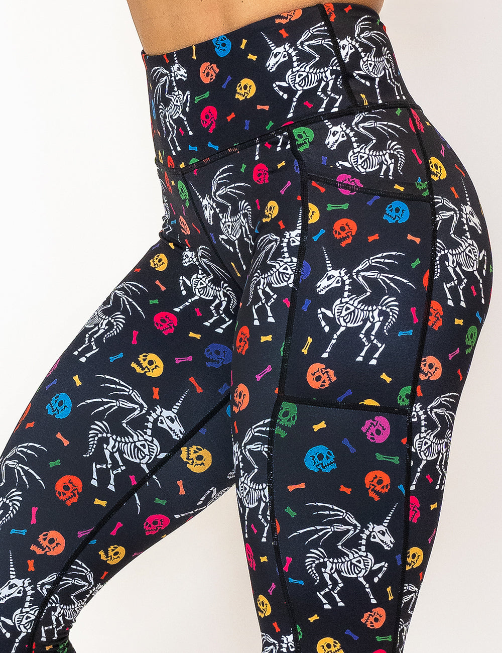 front of the unicorn skeleton and skulls pattern leggings against a white background