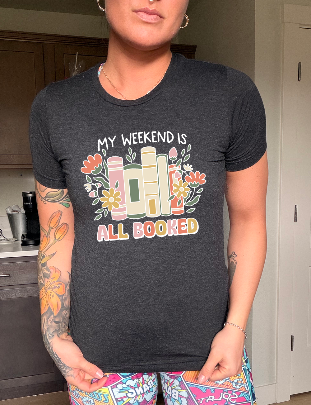 Black colored shirt with books and flowers graphic on it that says "My Weekend Is All Booked"