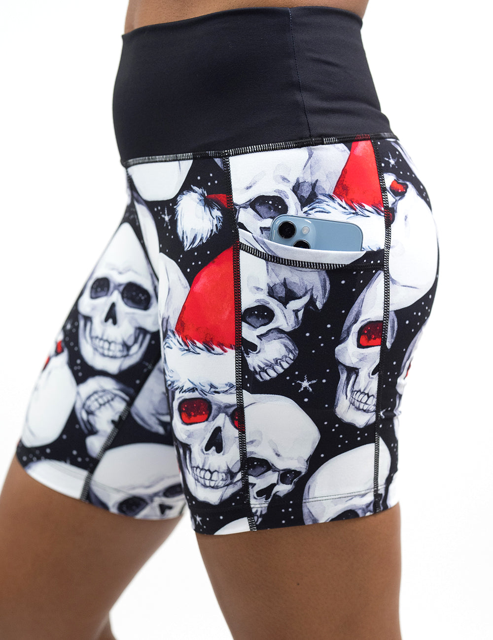 close up of the 7 inch santa hat and skull pattern shorts with a phone in the pocket