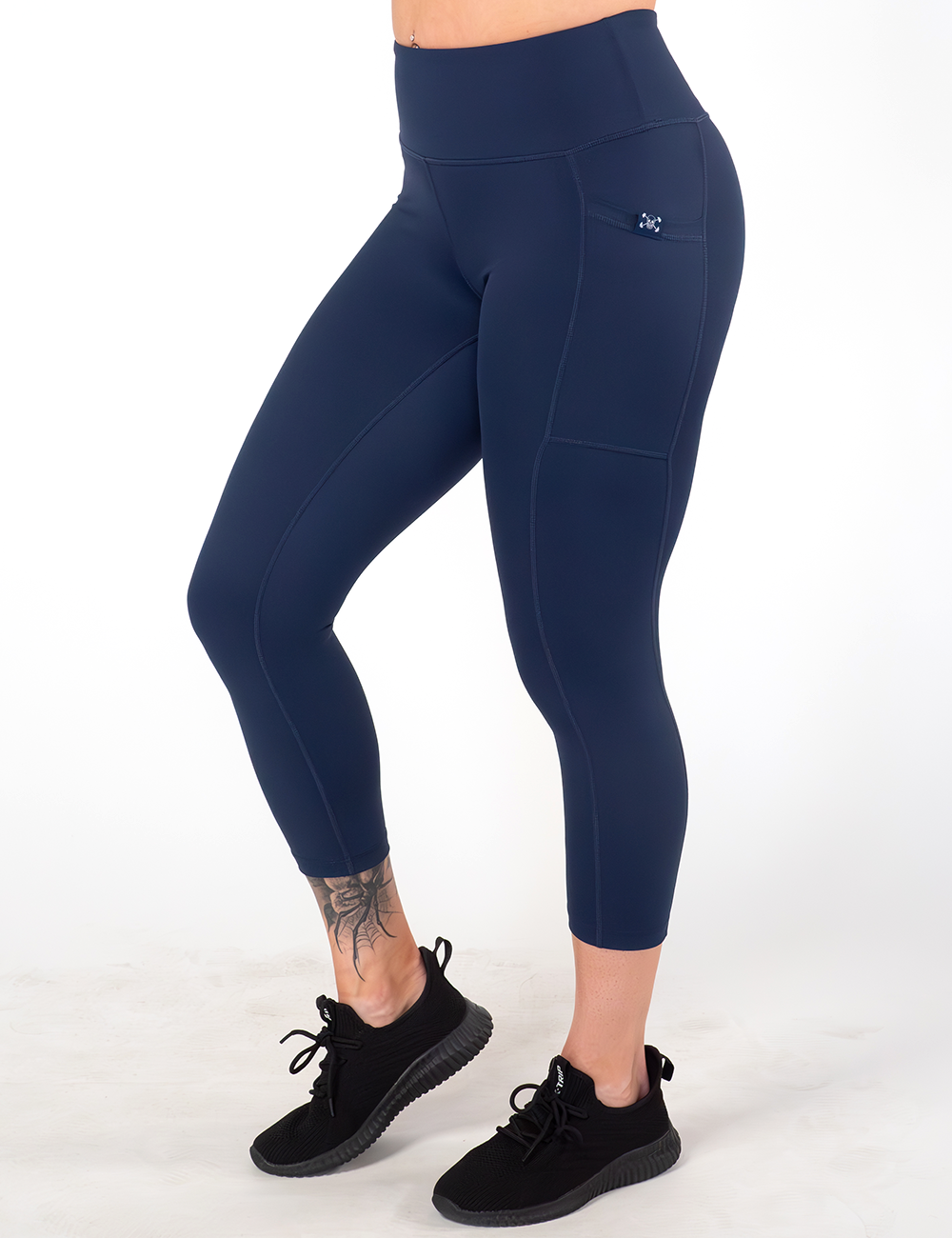 model wearing the capri solid navy blue leggings against a white background