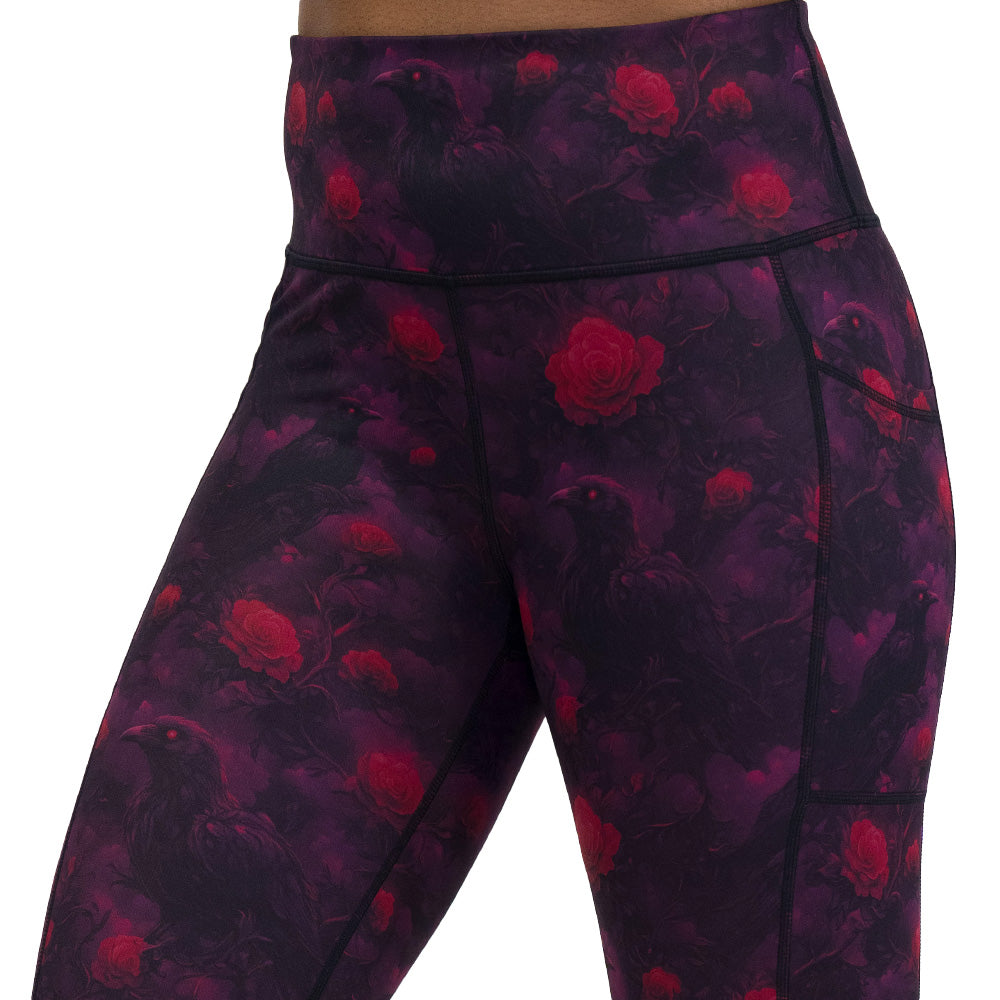 Black leggings with red floral and crow pattern on it