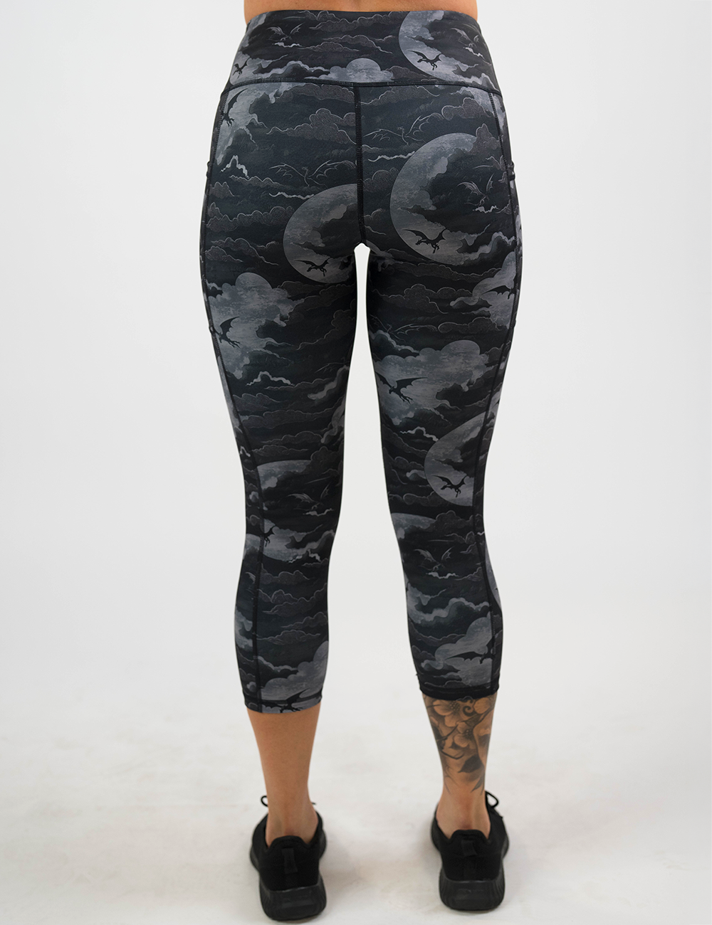 back of the dark dragons against a moonlight night sky capri leggings against a white background