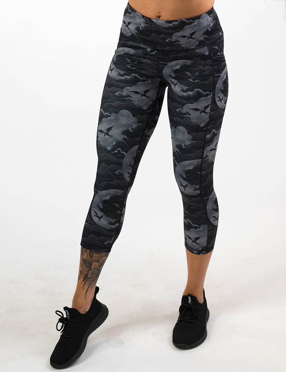 model wearing the dark dragons against a moonlight night sky capri leggings against a white background