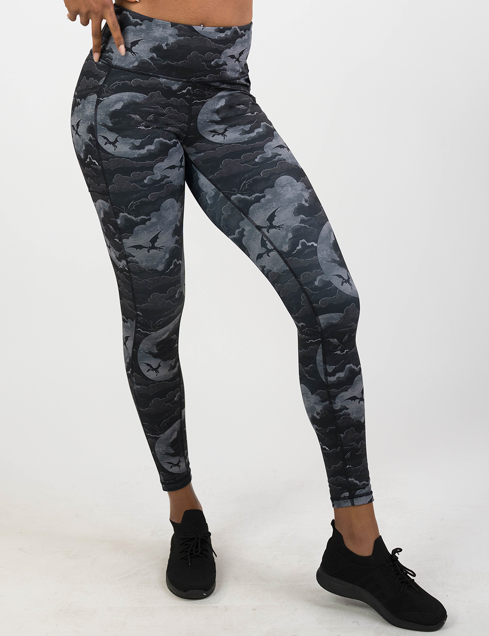 model wearing the dark dragons against a moonlight night sky full length leggings against a white background