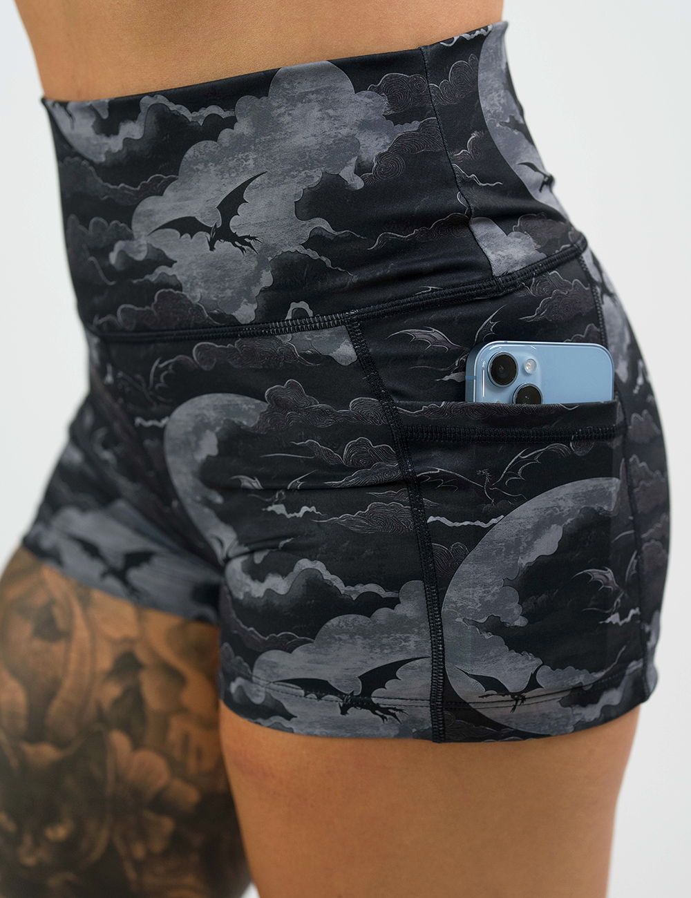 dark dragon against moonlit clouds pattern 2.5 inch shorts with a close up of the pocket holding a phone