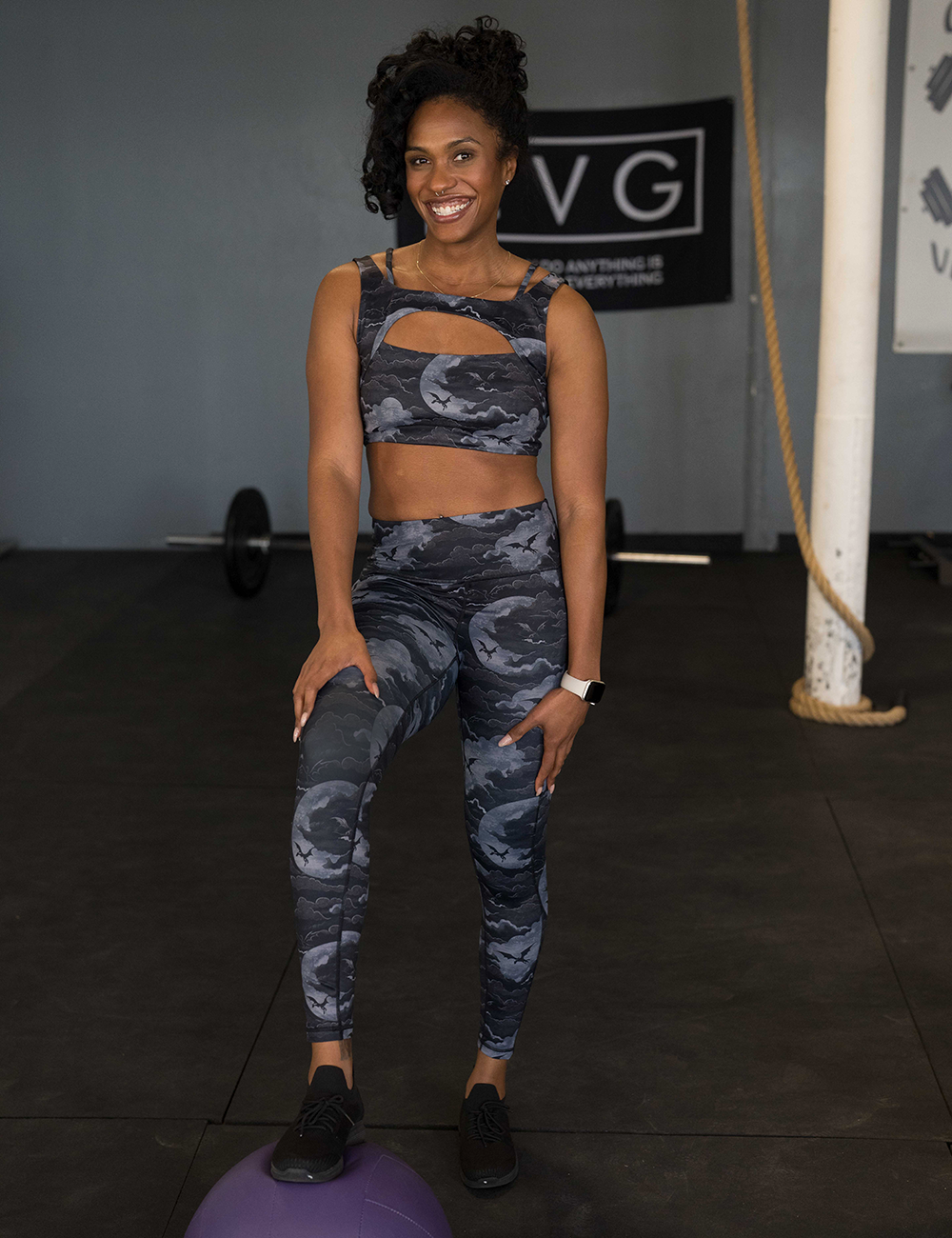 model wearing the ark dragons against a moonlight night sky full length leggings in the gym