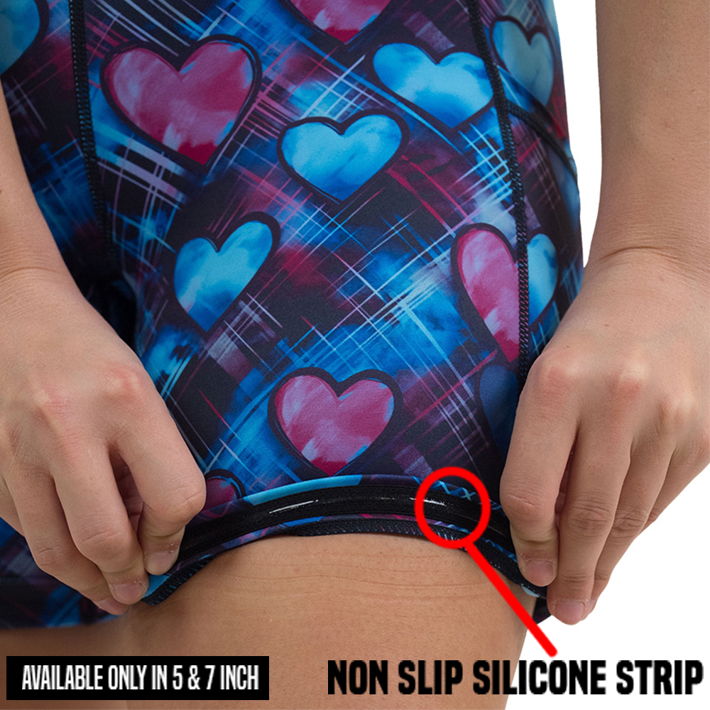 close up of the blue and pink hearts pattern against a dark stitched background shorts rolled up to display the non slip silicone strip available in the 5 and 7 inch inseam lengths