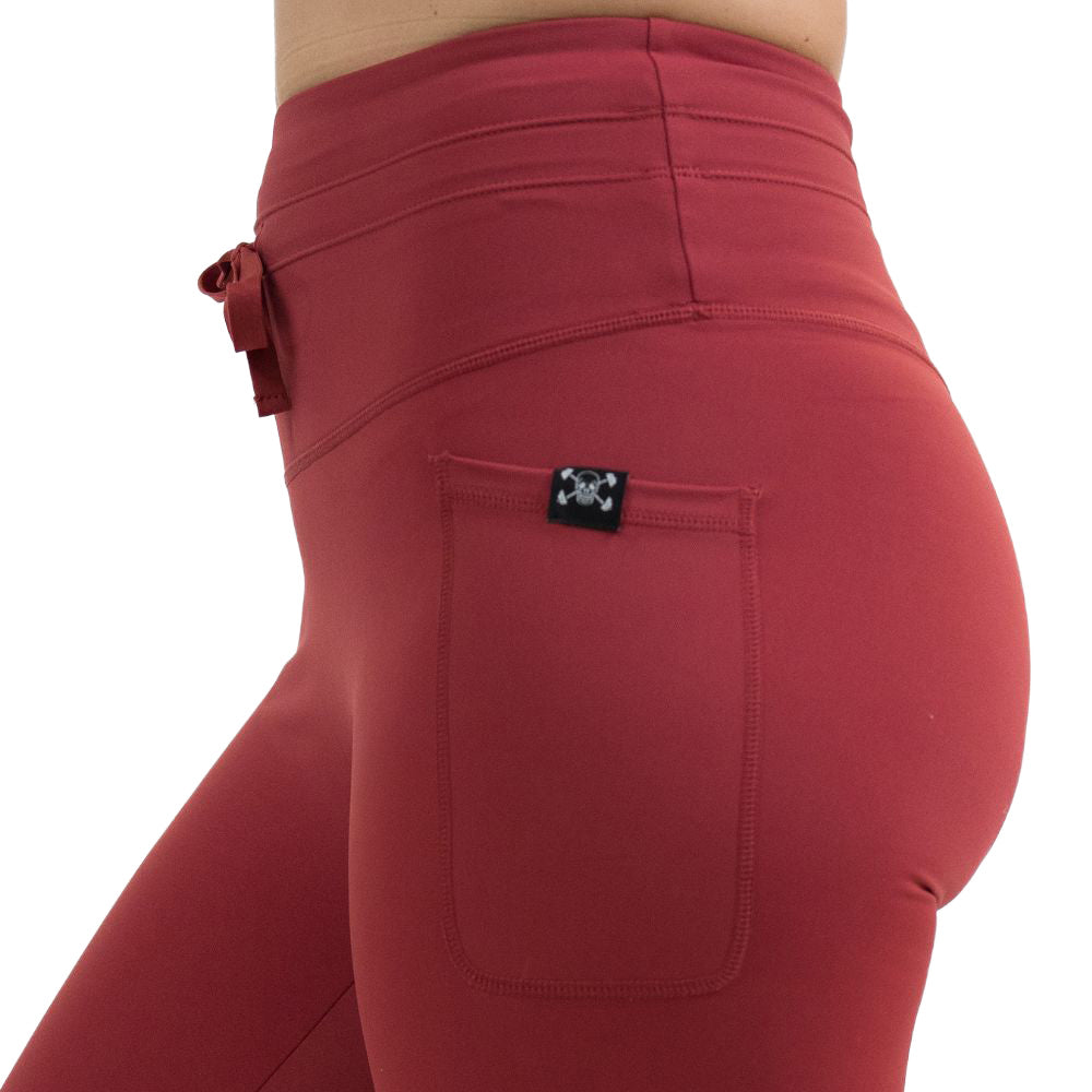 close up of the omni garnet red leggings facing the side against a white background