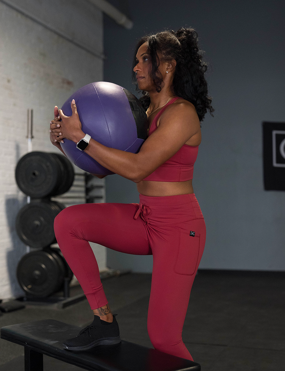 model wearing the omni garnet red leggings and bra during a workout
