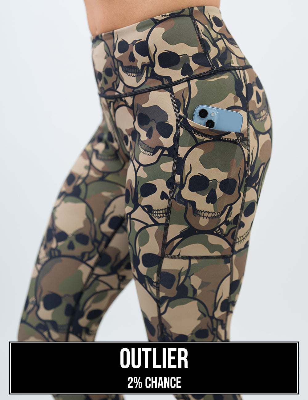 side view of the camo skulls leggings with a phone in its pocket, the name of this print is outlier and it has a 2% chance of being unboxed