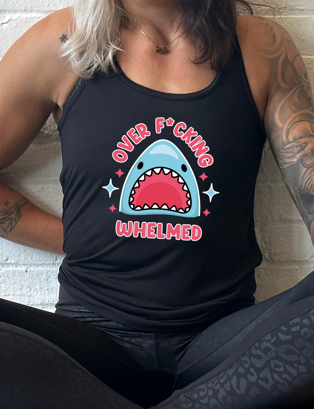 black racerback flowy tank with the graphic of a shark's head with mouth wide open, and the words around the graphic saying "over f*cking whelmed" and a few stars on the sides