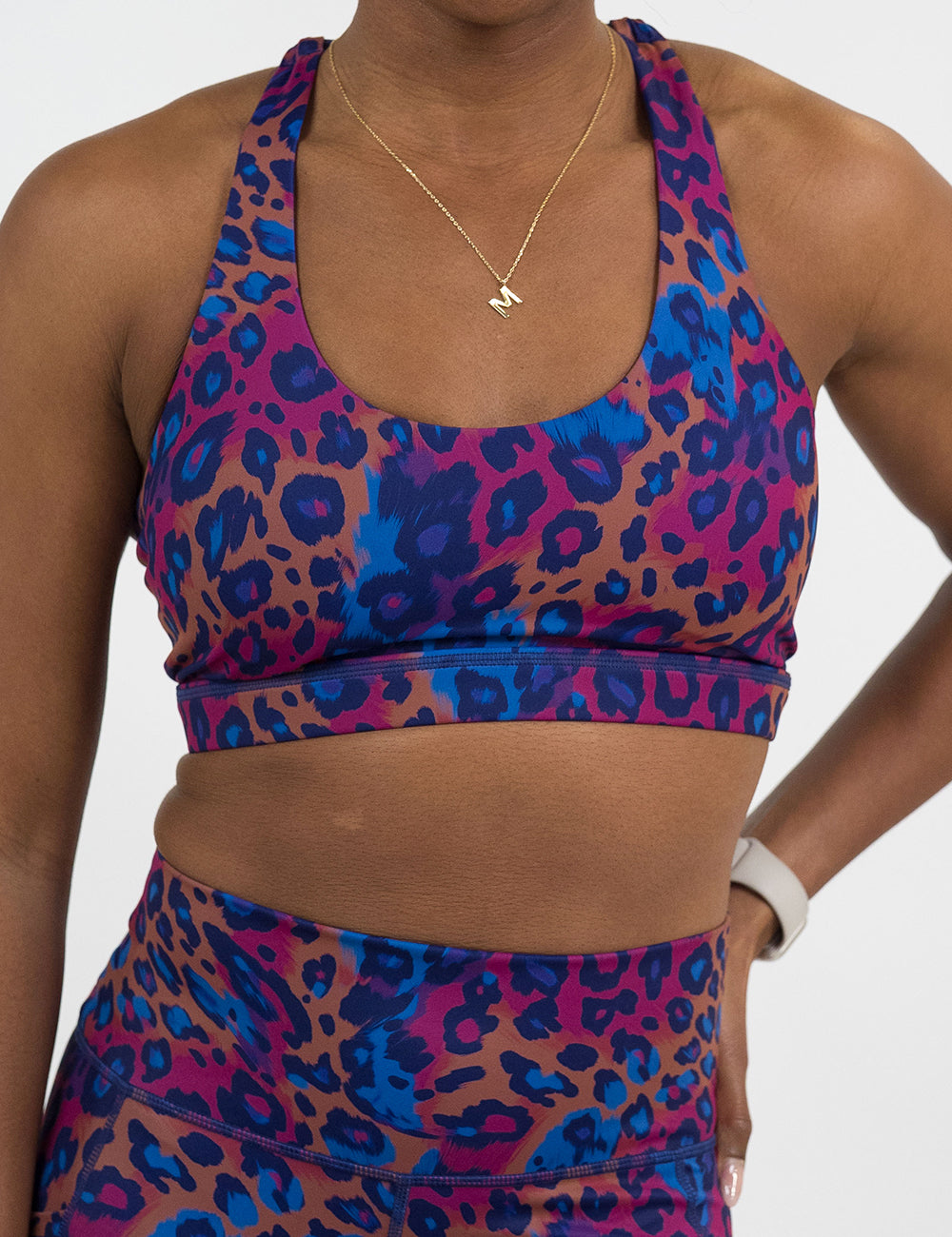 front of the cheetah print against a yellow, blue, and purple background pattern bra against a white background