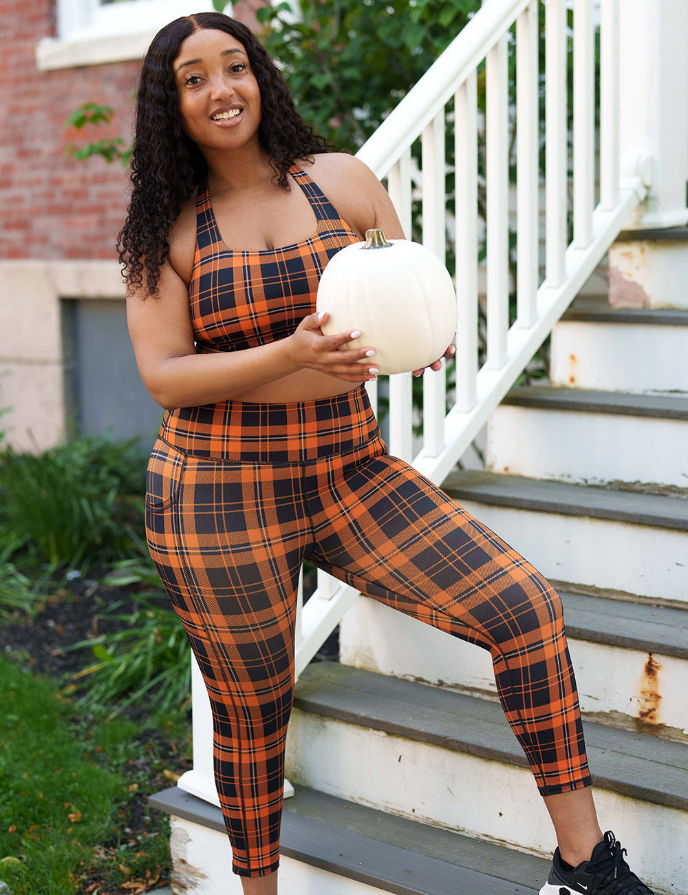 model wearing the capri black and orange plaid leggings