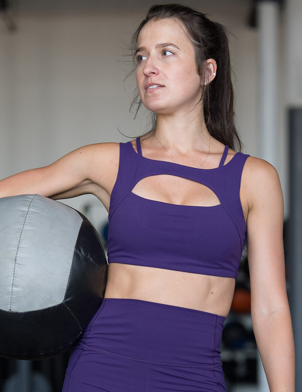 model wearing the solid purple sports bra in the gym