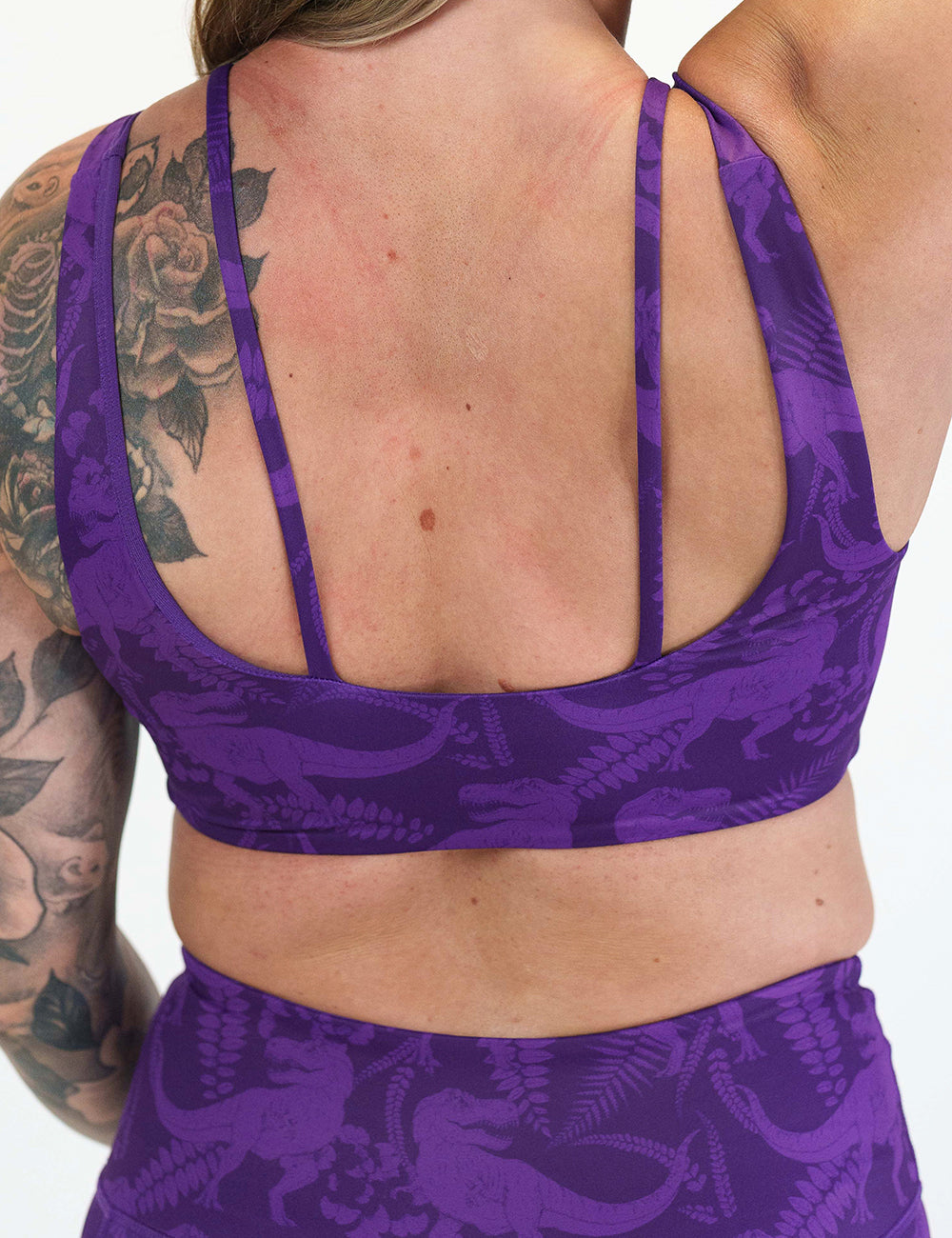 back of the purple dinosaur patterned sports bra