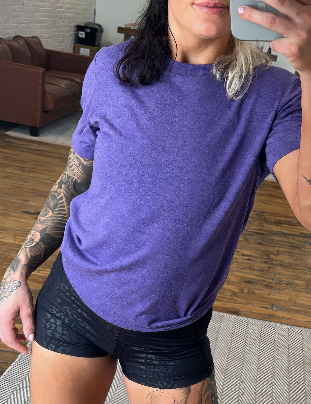 model wearing the purple unisex tee and 2.5 inch black leopard shorts