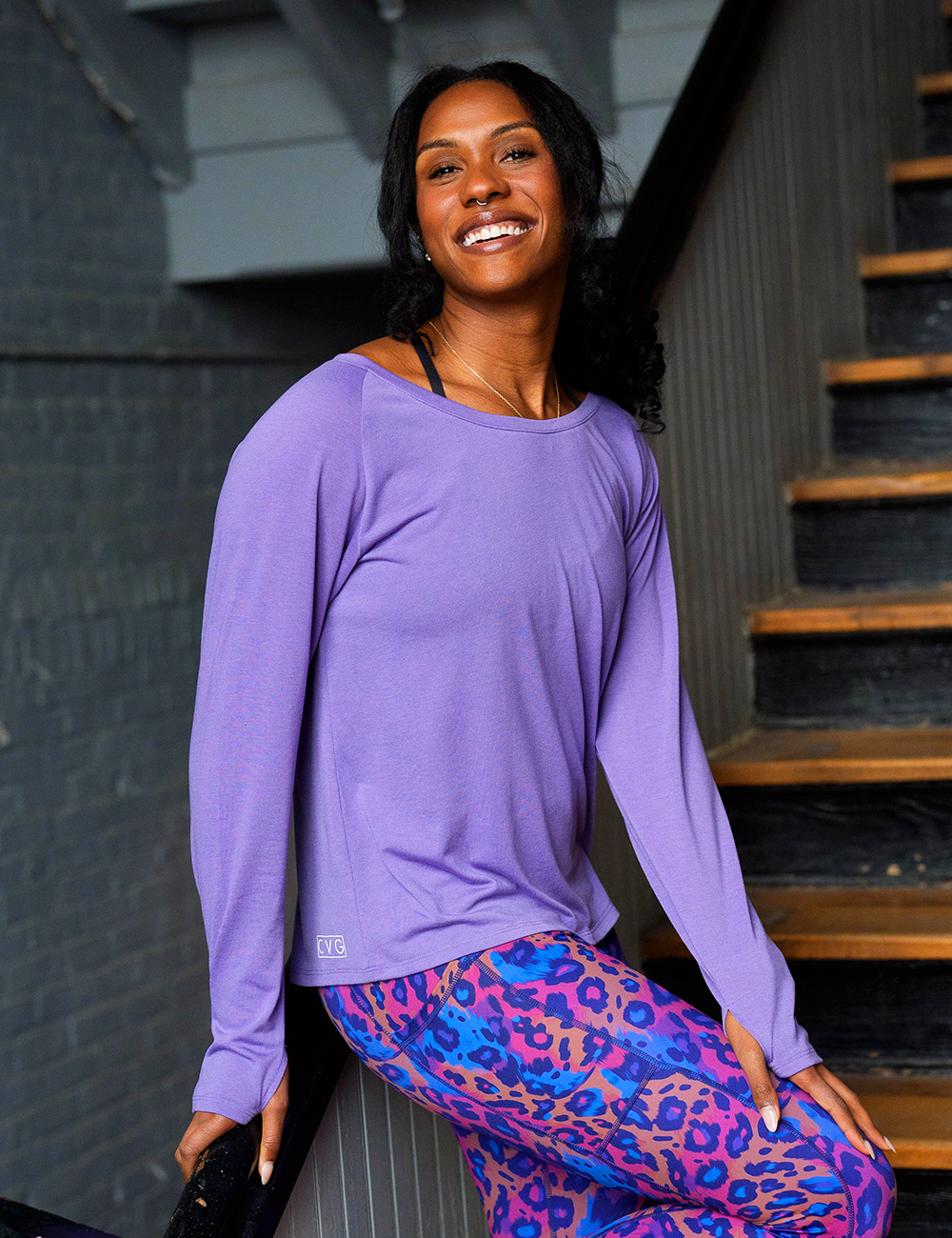 purple long sleeve slouchy tee with painted prowl multi colored cheetah print leggings in a stairwell